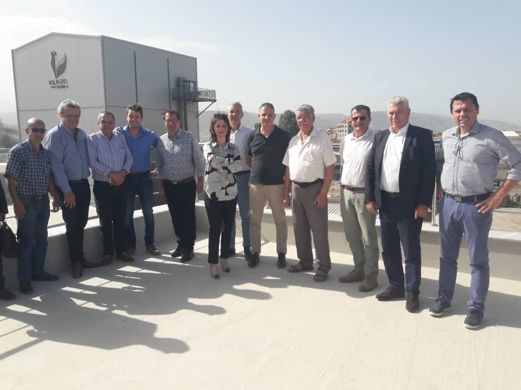 Groupe d'éleveurs et de techniciens réunis devant un bâtiment lors d'une visite.